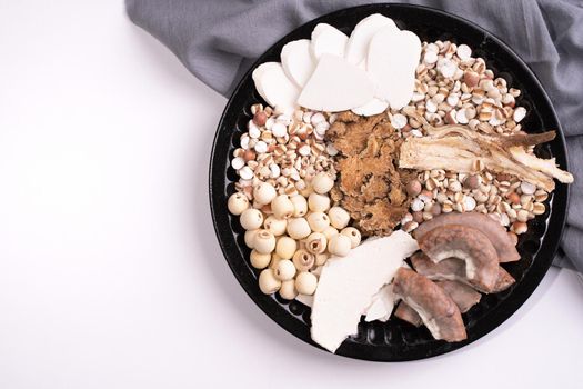 Ingredients of Four Tonics Soup, Four Herb Flavor Soup. Taiwanese traditional food with Job's tears, herbs, pork intestines on white background