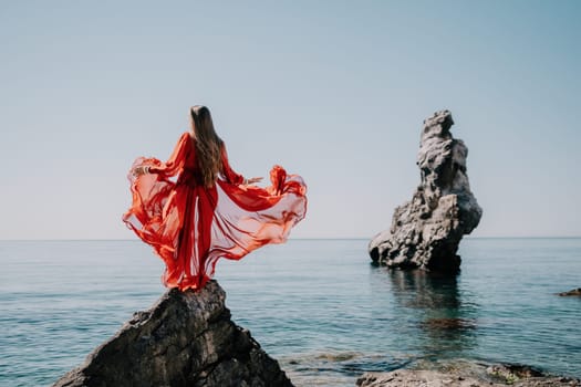 Woman travel sea. Happy tourist taking picture outdoors for memories. Woman traveler looks at the edge of the cliff on the sea bay of mountains, sharing travel adventure journey.