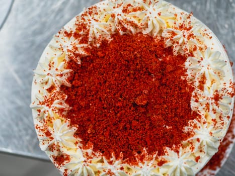 preparing red velvet frosted icing cup cake with sprinkles on top in the kitchen