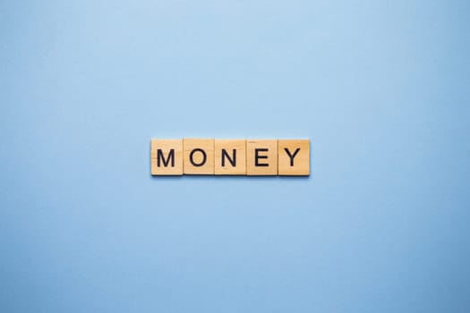 Finance concept. On a blue surface, wooden cubes with the inscription money