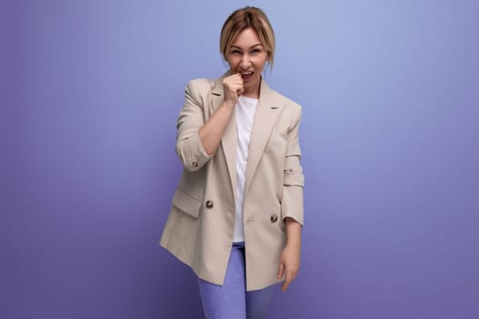 portrait of doubtful european blonde 30s business woman on studio background.