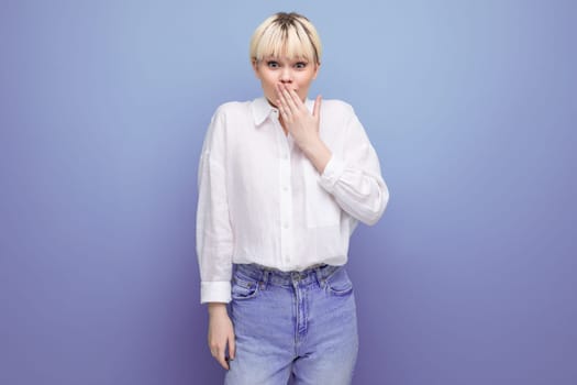young blond caucasian woman with a short haircut dressed in a white shirt keeps a secret.