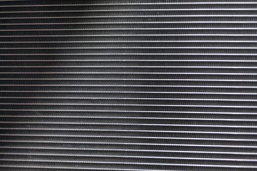 Texture of a car radiator. Engine cooler background. Vintage style. Radiator grille for car interior heater air conditioner, close-up. Radiator repair and replacement.