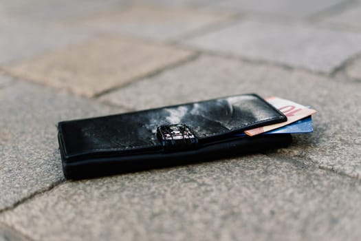 The wallet with coins on a sidewalk street, forgotten money