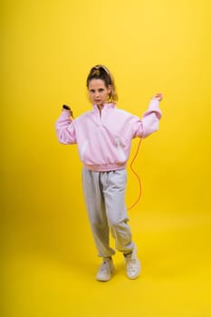 Adorable female child with skipping rope jumping in a studio