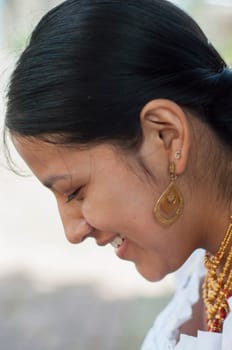 close-up of the profile of a pretty native woman with traditional earrings and necklaces and typical indigenous dress. High quality photo