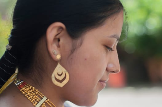 close-up of attractive indigenous woman with earrings, necklaces and traditional native dress. High quality photo