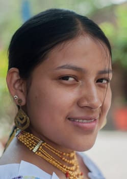 closeup of smiling attractive young indigenous woman with earrings and handicrafts of native latin america culture. High quality photo