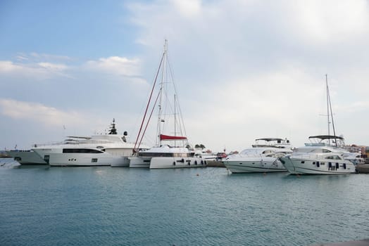 White luxury yachts in clean weather docking at bay with blue water and sky. High quality photo