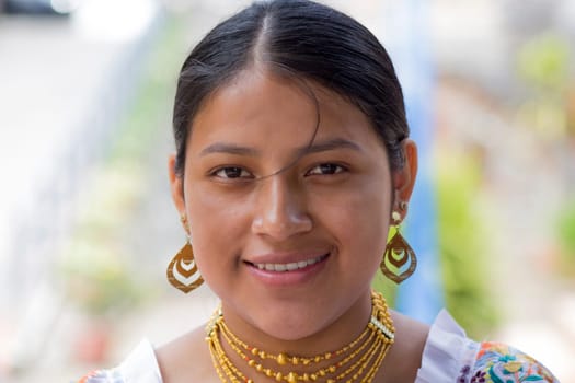 closeup of pretty smiling indigenous woman in traditional dress and earrings, necklaces and bracelets. High quality photo