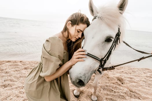 A white horse and a woman in a dress stand on a beach, with the sky and sea creating a picturesque backdrop for the scene