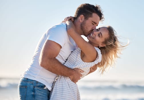 Love, dating and couple kiss at beach enjoying summer holiday, vacation and honeymoon by the sea. Travel, romance and man and woman show affection, embrace and bonding in nature on weekend together.