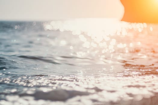 Abstract nature summer or spring ocean sea background. Small waves on water surface in motion blur with bokeh lights from sunrise.