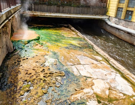 Tepla river under the bridge Vridelni lavka. Water full of mineral sediments and algae.  Karlovy Vary Carlsbad, Czech Republic