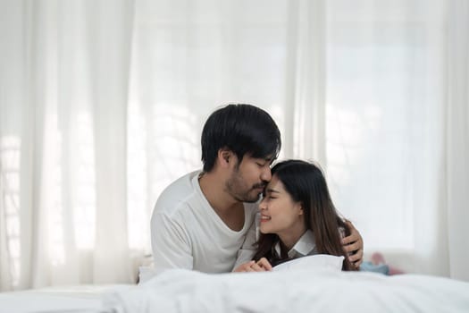 Young couple lying together in bed in the bedroom.