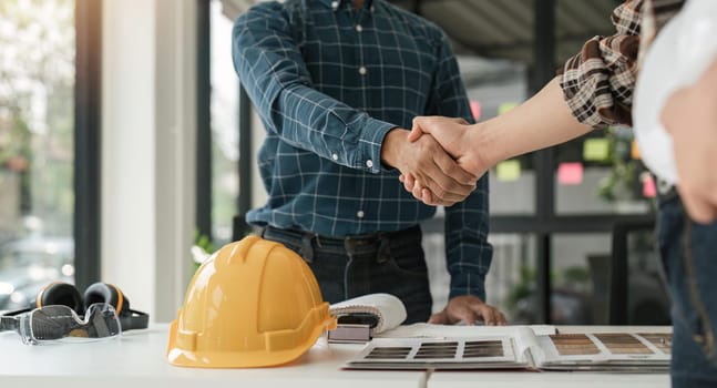 Engineer and contractor shaking hands success of the project work together.