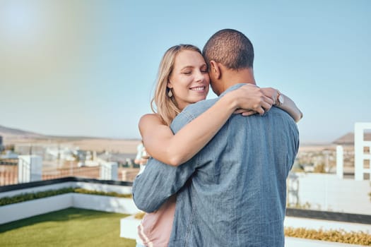 Couple, love and hug on city building rooftop for date, romance and quality time while dancing and happy together. Interracial man and woman on vacation in Cape town in summer for cityscape travel.