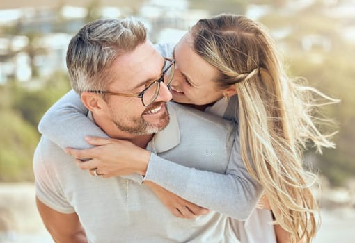 Hug, love and couple with a smile, beach or romance with relationship, marriage or summer vacation. Romantic, mature man or woman embrace, seaside holiday or bonding with happiness or loving together.