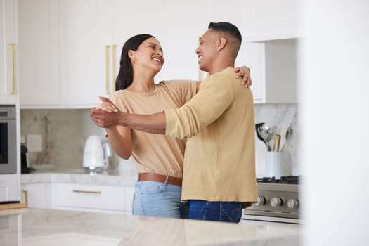 Love, smile and couple dance in kitchen, celebrating anniversary and bonding. Happy, man and woman dancing, romance and affection, carefree or playful people having fun spending time together in home.