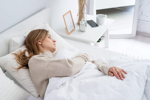 caucasian Woman sleeping at bed at home. young millennial woman sleeping, morning light on the bed