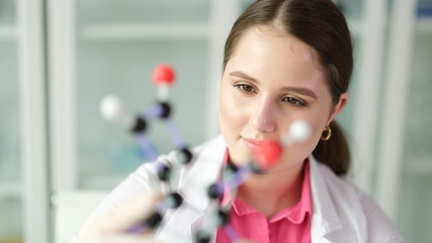 Woman scientist chemist studying molecule structure on plastic 3d model. Chemistry education concept