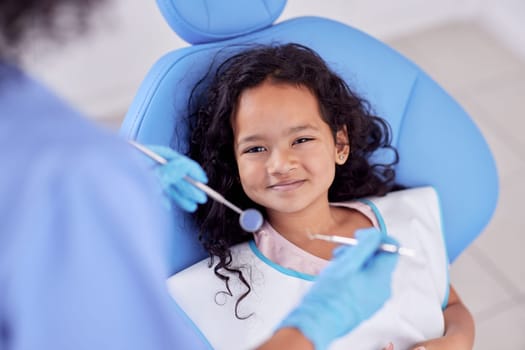 Dentistry, portrait and girl child at the dentist for teeth cleaning, oral checkup or consultation. Healthcare, smile and kid laying on the chair for dental mouth examination with equipment in clinic.