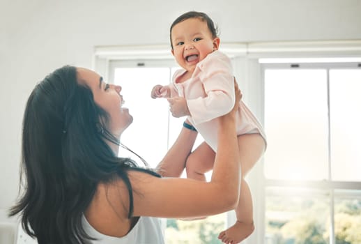 Funny, mother and lifting baby, care and bonding together with infant in home. Smile, mama and raise newborn, child or kid, playing and having fun, happiness or enjoying quality time with family love.