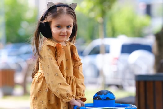 Happy little girl is playing on the playground in the park.