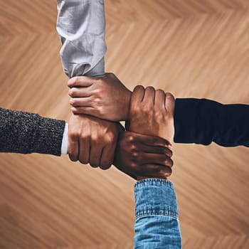 Collaboration, link or hands of business people with diversity for community support or teamwork in office. Zoom, above or group of employees with joint mission, trust or hope for goals together.