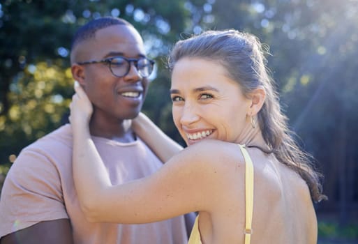 Happy woman, smile and interracial couple for hug, love or care for summer holiday, relationship or bonding in the park. Female holding man smiling in happiness for quality time, romance or embrace.