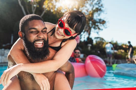 Pool party, love and couple piggyback, having fun or bonding. Swimming, romance diversity and happy black man carrying woman in water and laughing at comic joke or meme at summer event or celebration.