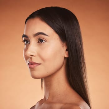 Woman, silky hair and face beauty wellness lifestyle or luxury skincare. Young aesthetic model, natural cosmetic haircare or makeup, calm facial expression and vision look in orange background studio.