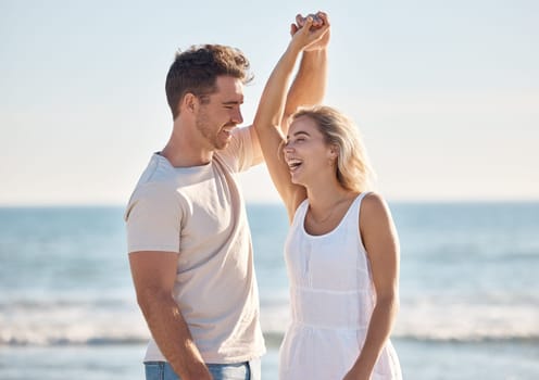 Beach, love and dance with a young couple in nature, happy together during a date or summer vacation. Smile, travel and romance with a man and woman dancing by the sea or ocean while bonding.