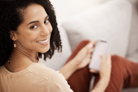 Black woman, happy with smartphone and smile in portrait, relax on living room sofa with social media or texting. Communication, technology and online, relaxing at home with 5g network and mobile