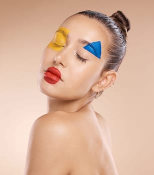 Woman, creative clown makeup on face and close eyes expression. Portrait of beauty cosmetic skincare model, circus or fantasy abstract facial paint and art design against orange studio background.