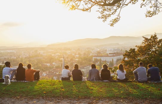 Ljubljana, Slovenia, October 2020: People sit on the mountain and admire the sunset over the autumn Ljubljana