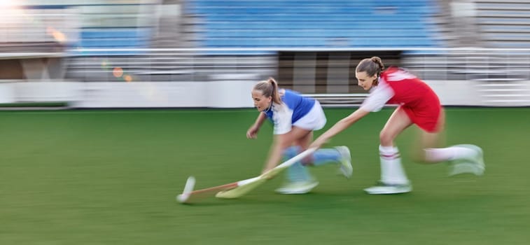 Hockey, action and running women in a game, competition or sports event for goal with speed, energy and motivation challenge. Stadium, turf field and athlete people run together with stick and a ball.