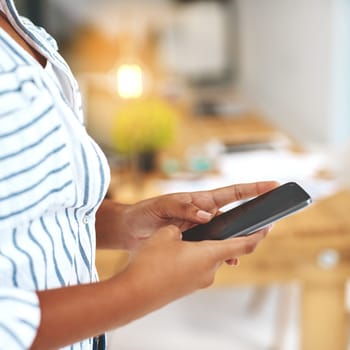 Cropped shot of an unrecognizable young woman using her cellphone.