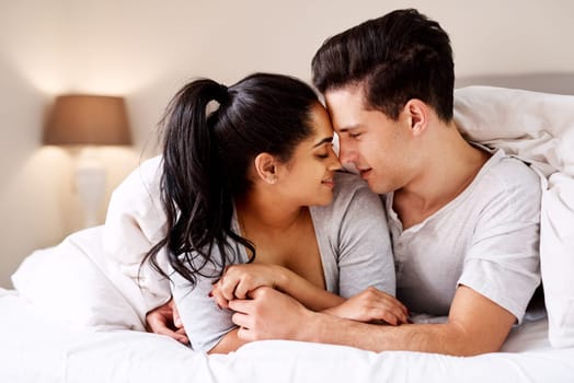 Love, bed and morning with a diversity couple in the bedroom of their home together for romance or intimacy. Sensual, foreplay or passion with a young man and woman in a house for romantic bonding.
