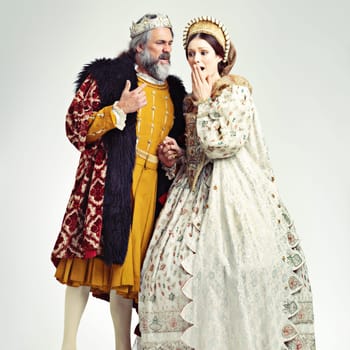 King, queen and surprised in medieval costume for royal party, retro carnival and theatre fashion clothes in white background. Couple, shocked face and vintage renaissance standing isolated in studio.