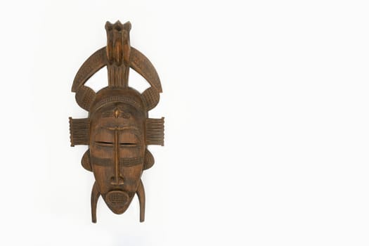 Brown wooden mask isolated on a white background Copy space