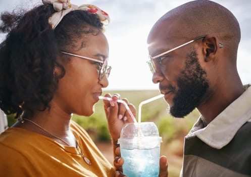 Love, share and drink with straw and couple in nature for travel, countryside and sunset date on Madrid vacation. Happy, summer and romance with black man and woman drinking together on holiday.