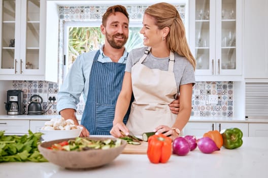 Love, health and happy couple cooking in the kitchen with healthy food or vegetables for lunch or dinner. Smile, house and happy woman enjoys salad preparation with a hungry vegan partner in Sydney.