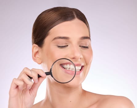 Magnifying glass, teeth or woman with dental, smile or natural face beauty in oral health hygiene routine. Search, tooth or happy girl model with lens for wellness, clean mouth or treatment in studio.