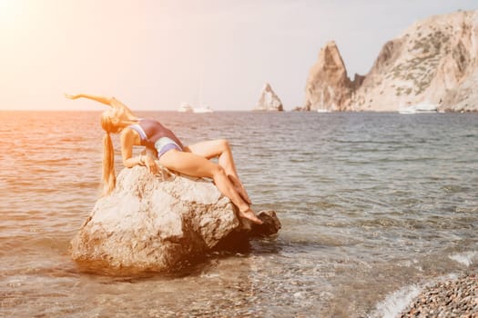 Woman travel sea. Young Happy woman in a long red dress posing on a beach near the sea on background of volcanic rocks, like in Iceland, sharing travel adventure journey