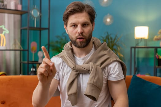 Displeased upset man reacting to unpleasant awful idea, dissatisfied with bad quality, wave hand, shake head No, dismiss idea, dont like proposal. Young Caucasian guy at home apartment room on sofa
