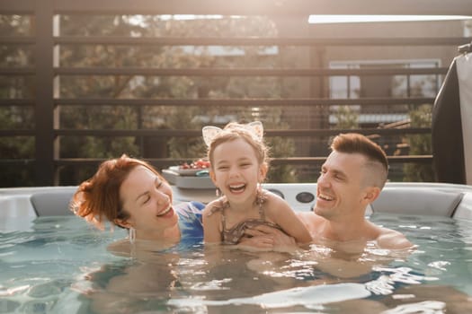 In summer, the family rests in the outdoor hot tub.