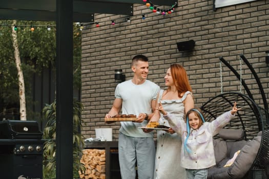 A happy family has prepared lunch and will eat at their house. Portrait of a family with food in their hands.