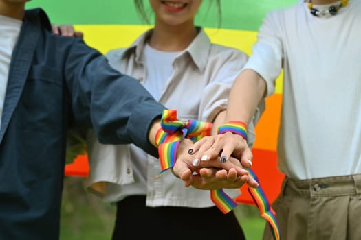 Group of friends, homosexual community people stacking hands together, showing freedom and unity, shooting of equality social.