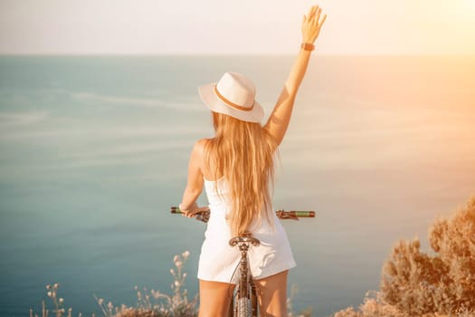 Woman travel bike sea. Happy woman cyclist sitting on her bike, enjoying the beautiful mountain and sea landscape, signifying the idea of an adventurous bike ride